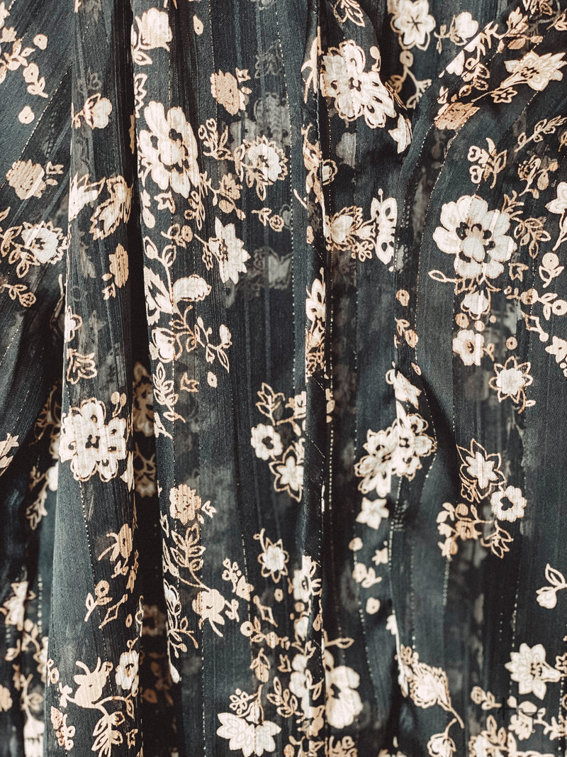 Photo of close up of gold and cream floral print on black blouse