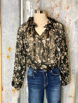 Photo of black and gold floral print blouse on mannequin with tin background