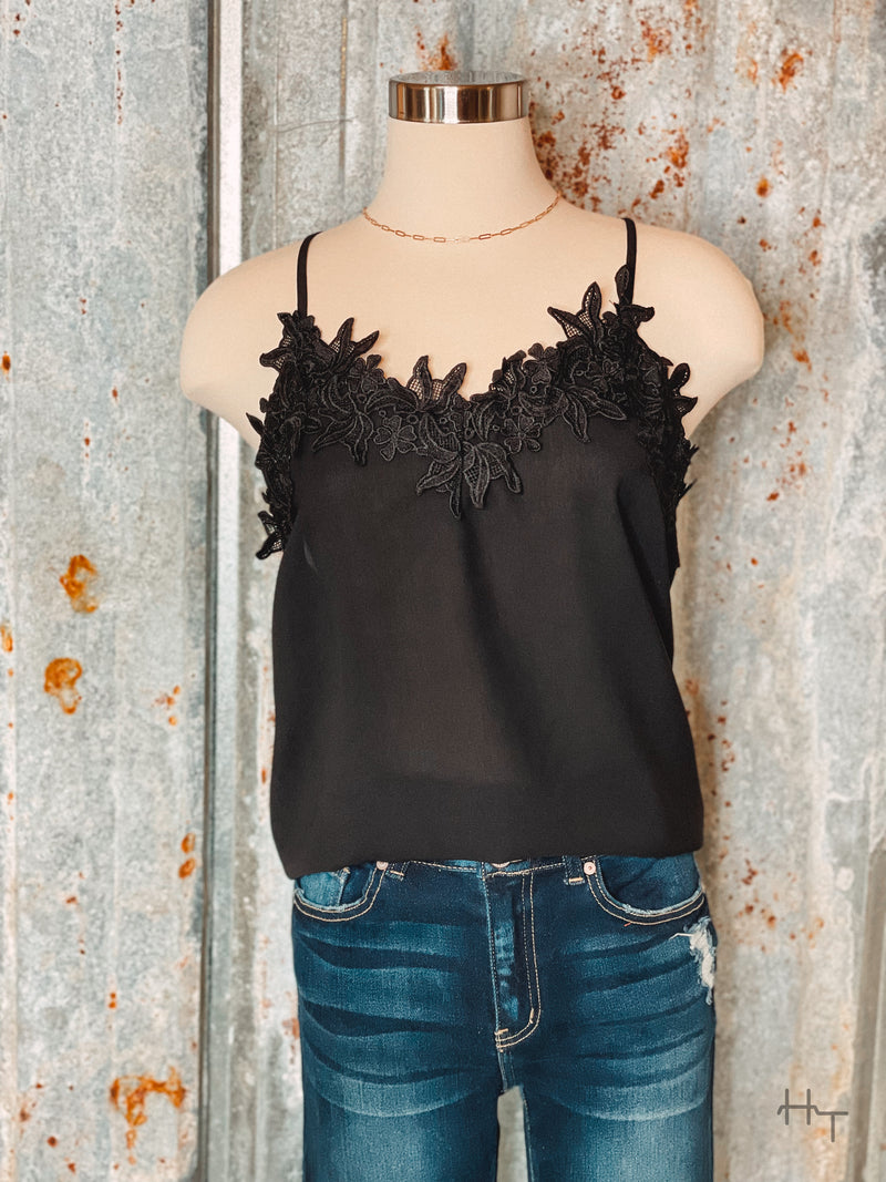 Photo of black cami with floral lace trim on mannequin with tin background
