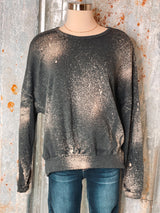 Photo of charcoal sweatshirt with bleach spot details on a mannequin with tin background