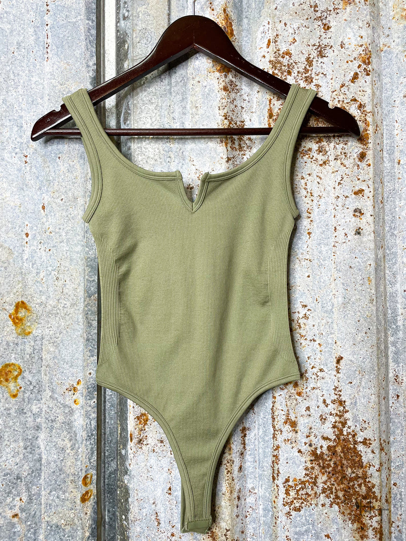 Photo of front view of olive green bodysuit on hanger