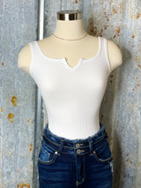 Photo of white bodysuit on mannequin with denim jeans on.
