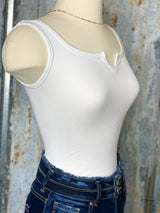 Photo of side view of white bodysuit on mannequin with denim jeans on.