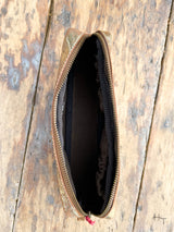 Photo of inside of metallic gold cosmetic bag with fabric liner and elastic slip pockets