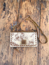 Photo of front of metallic gold leather purse with crossbody strap with leather sts patch