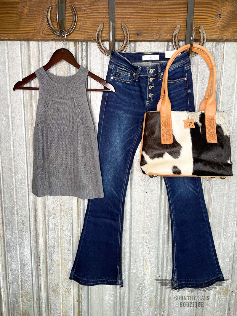 Image of dark grey halter neck knit tank with a pair of blue denim pants and a black and white cowhide purse with leather handles.