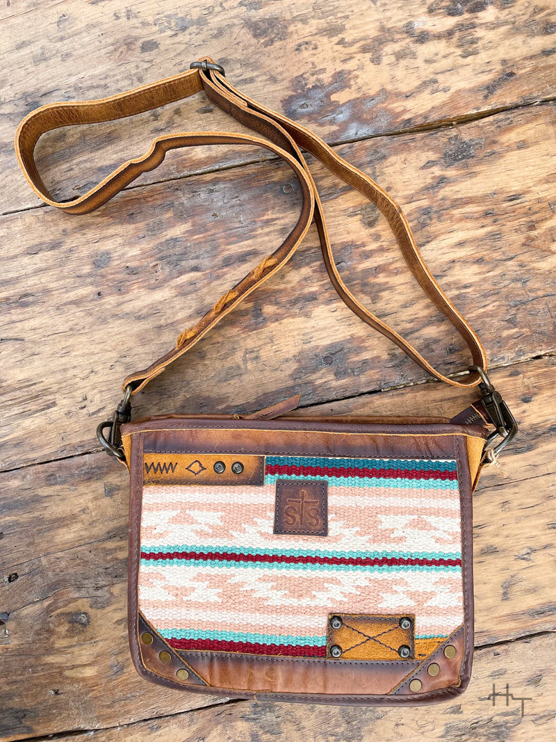 Photo of front of leather purse with pastel aztec print with sts leather patch on front and long crossbody strap