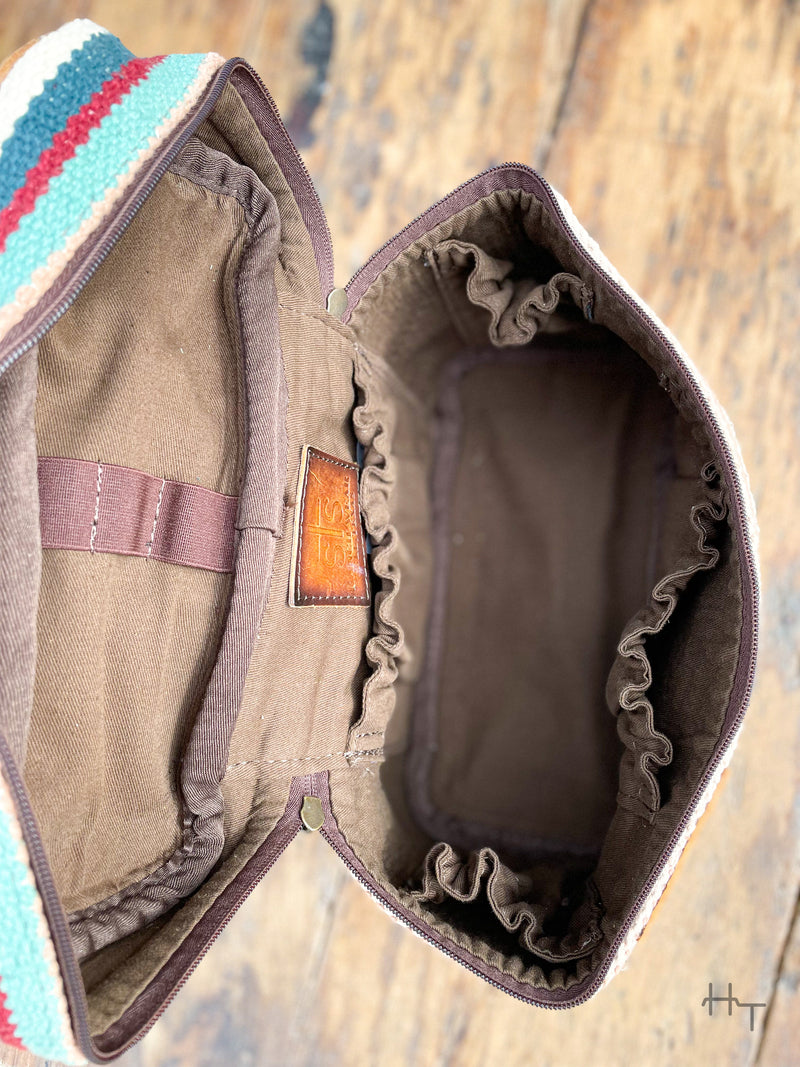 Photo of inside of train case with brown cloth liner elastic brush holder on inside of lid and 4 elastic slip pockets