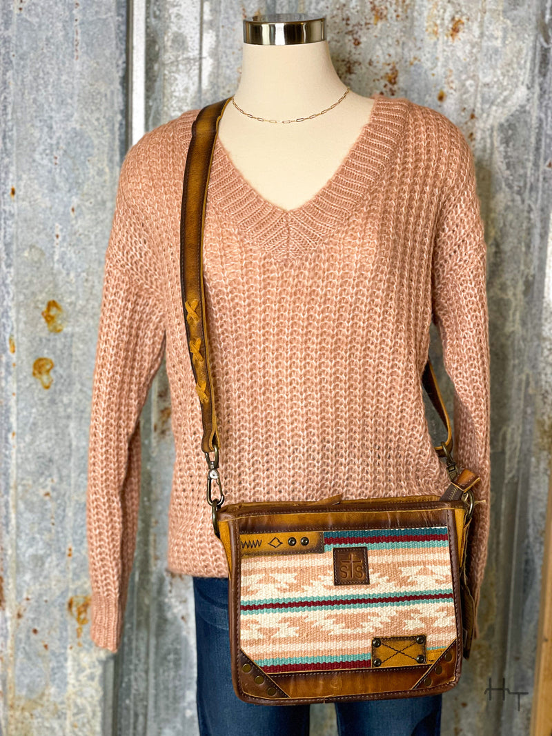 Photo of mannequin with rose pink knit sweater with leather and pastel serape woven purse