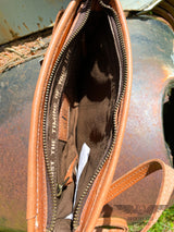 Image of interior of the Yipee Kiyay Claire crossbody purse.  Brown cloth interior with zipper pocket, leather STS branded patch, and inspirational quote "Trust the timing of your life".  Zipper closure.