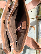 Image of one interior pocket of the yipee kiyay tote purse with brown cloth  interior liner and conceal carry holster, STS Ranchwear leather patch, and magnetic snap closure.